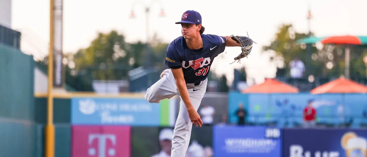 Tyler Bremner, in a Team USA uniform, caught in a freeze-frame after delivering a pitch.